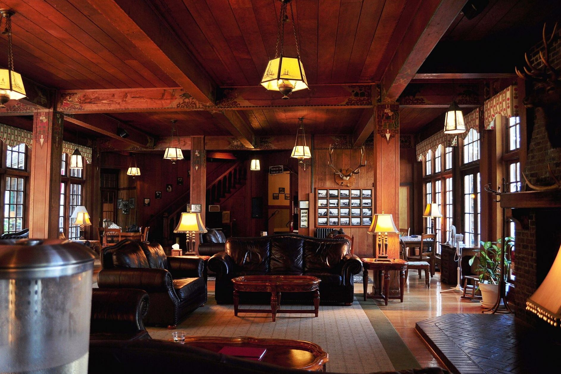 Warmly lit timber great hall with seating arranged around a central hearth
